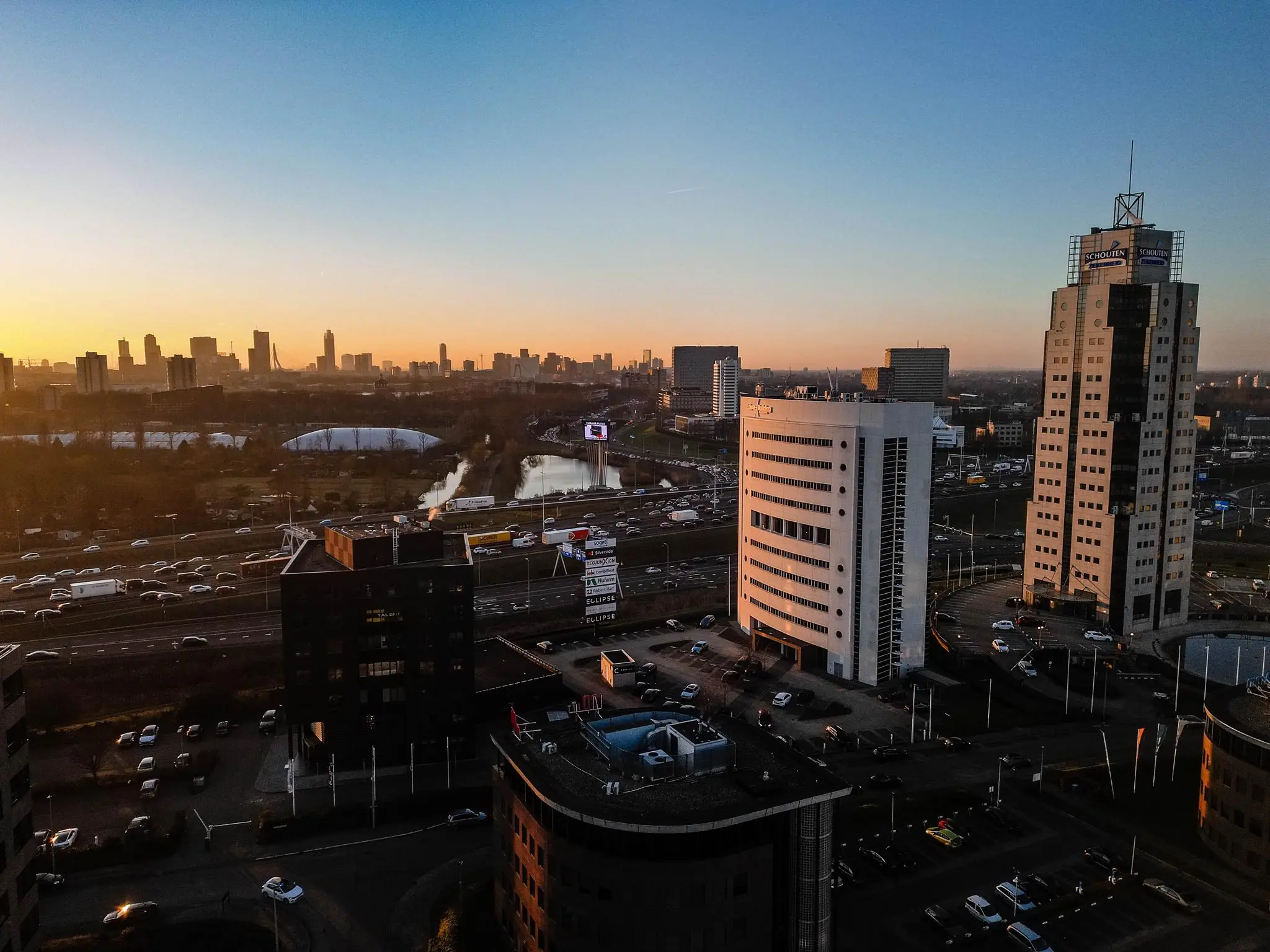 Luchtfoto van Rivium Quadrant in Capelle aan den IJssel met uitzicht op de skyline van Rotterdam bij zonsondergang.
